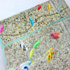 A glass aquarium filled with small gravel and ten colorful artificial tropical fish swimming.