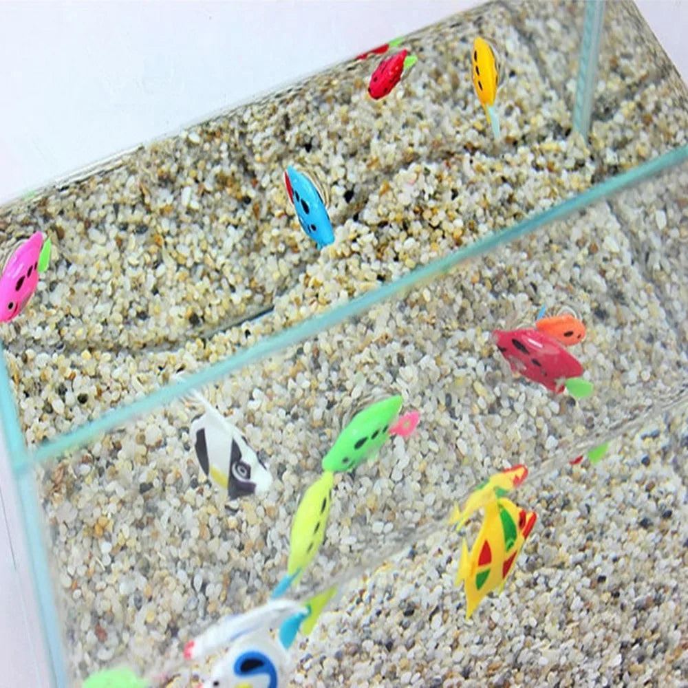 A glass aquarium filled with small gravel and ten colorful artificial tropical fish swimming.