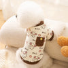 A white fluffy dog vest with a light pattern featuring cartoon dogs and brown accents.