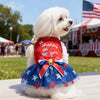 Ein weißer Hund trägt ein patriotisches Netzkleid mit roten, weißen und blauen Sternen und Streifen.