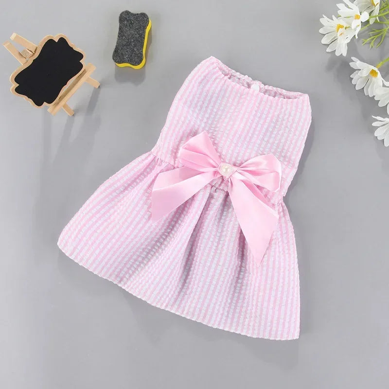 Pink gingham bow dress for small pets, featuring a pink checkered fabric and a large pink bow detail.