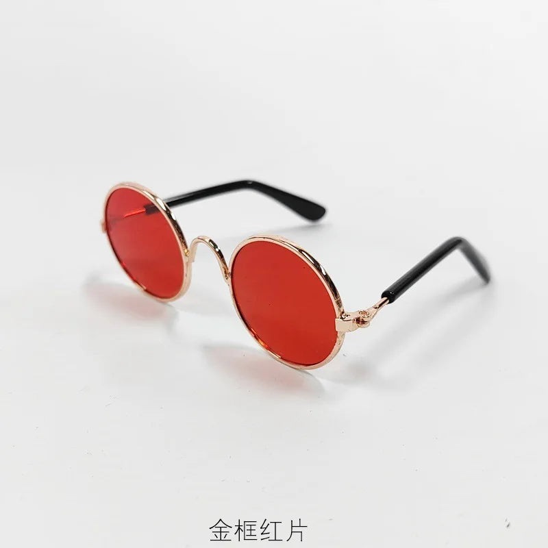 A pair of vintage round pet sunglasses in red-orange and gold metal frame.