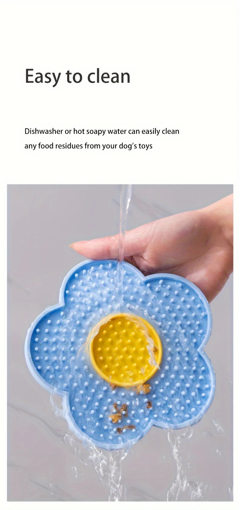A hand is washing a blue silicone flower-shaped mat under running water to clean food residues from dog toys.