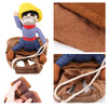 A plush toy dressed as a cowboy, next to a brown dog jacket and accessories.