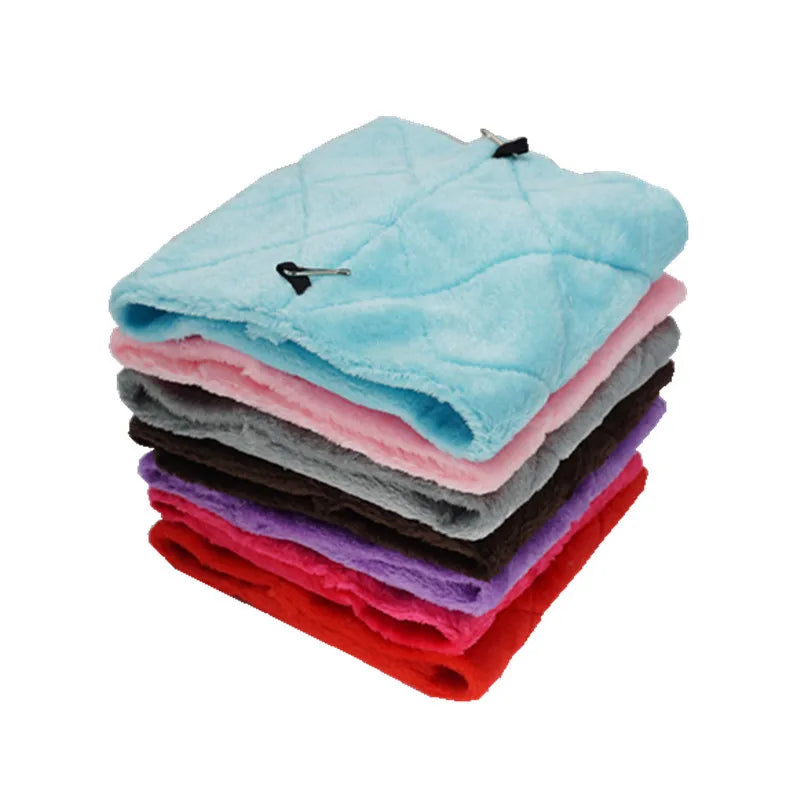 A stack of colorful plush bird hammock tents in shades of blue, pink, gray, black, purple, and red.