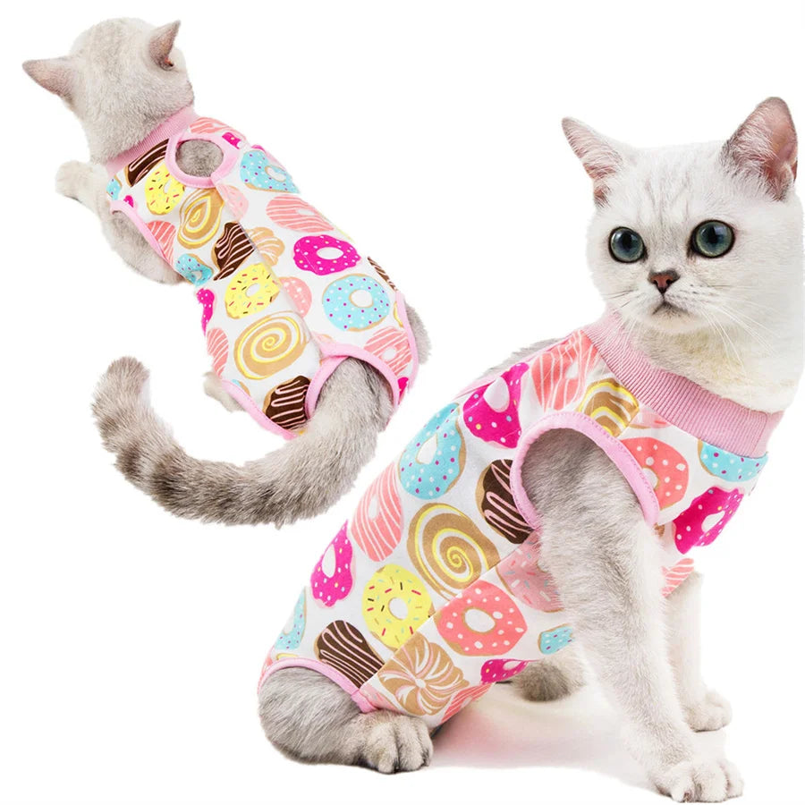 A gray cat wearing a pink and colorful patterned recovery vest.
