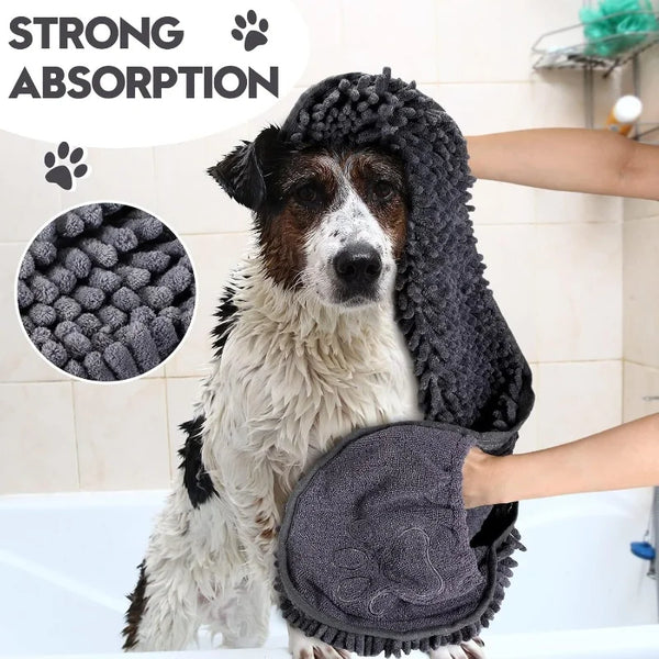 Un chien utilise une serviette grise foncée pour sécher son pelage dans la baignoire.