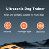 An overhead view of an orange ultrasonic dog trainer device with infrared and flashlight light features.