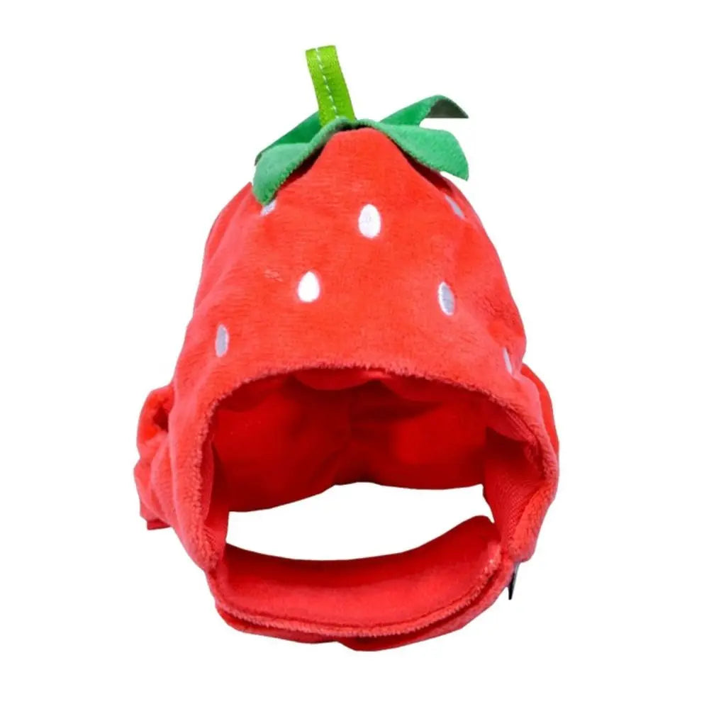 A bright red strawberry shaped pet hat for cats and dogs with green leaves.