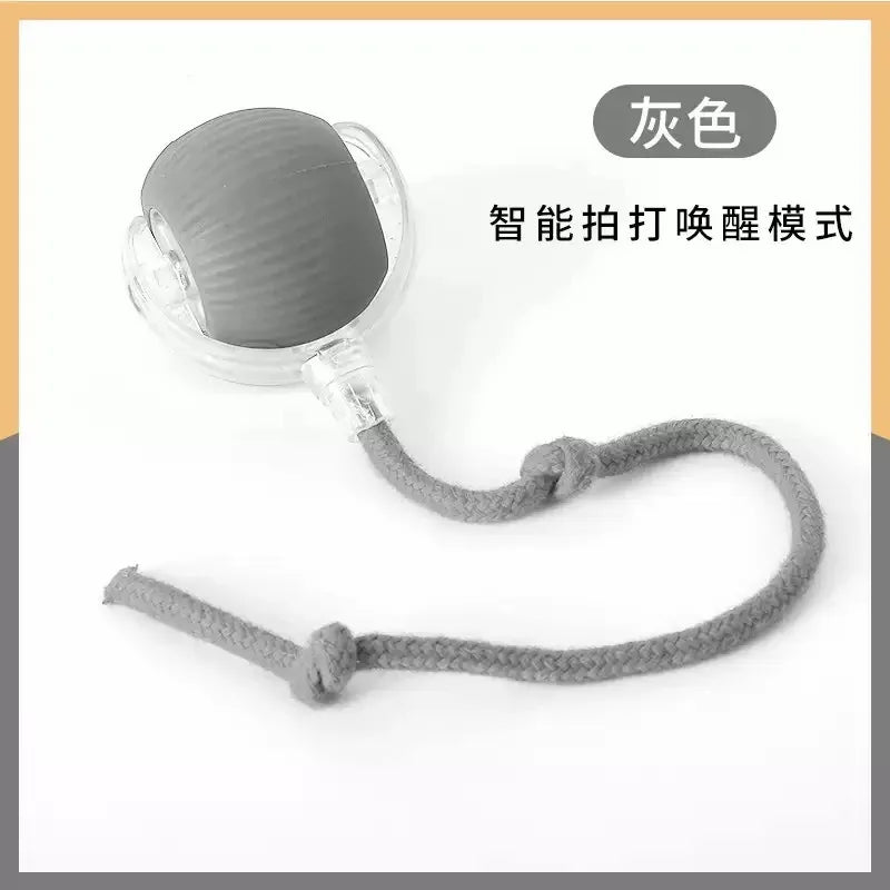 A gray smart pet ball with a cord, designed for a touch-activated mode.