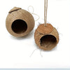 A natural coconut shell bird nest house with a lid is shown hanging by a twine lanyard.