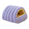 A lavender plush cat cave bed with a removable beige cover, shown from the side.