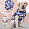 A golden retriever wearing a blue and gray camouflage dog vest with a tail hole detail.