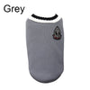 Un pull pour chien gris avec une bordure noire et un emblème brodé sur la poitrine.