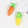 An orange carrot shaped squeaky chew toy for dogs, next to a green corn cob.
