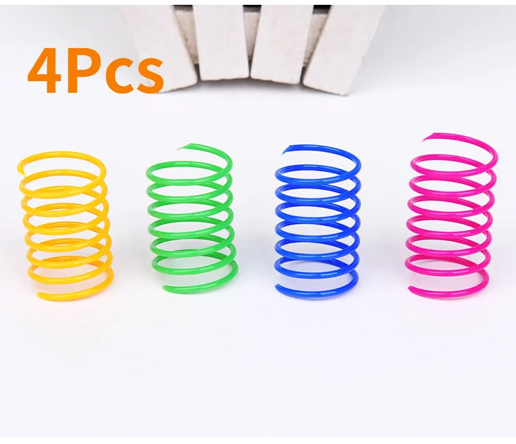 Four colorful spiral spring cat toys in yellow, green, blue, and pink arranged on a white background.
