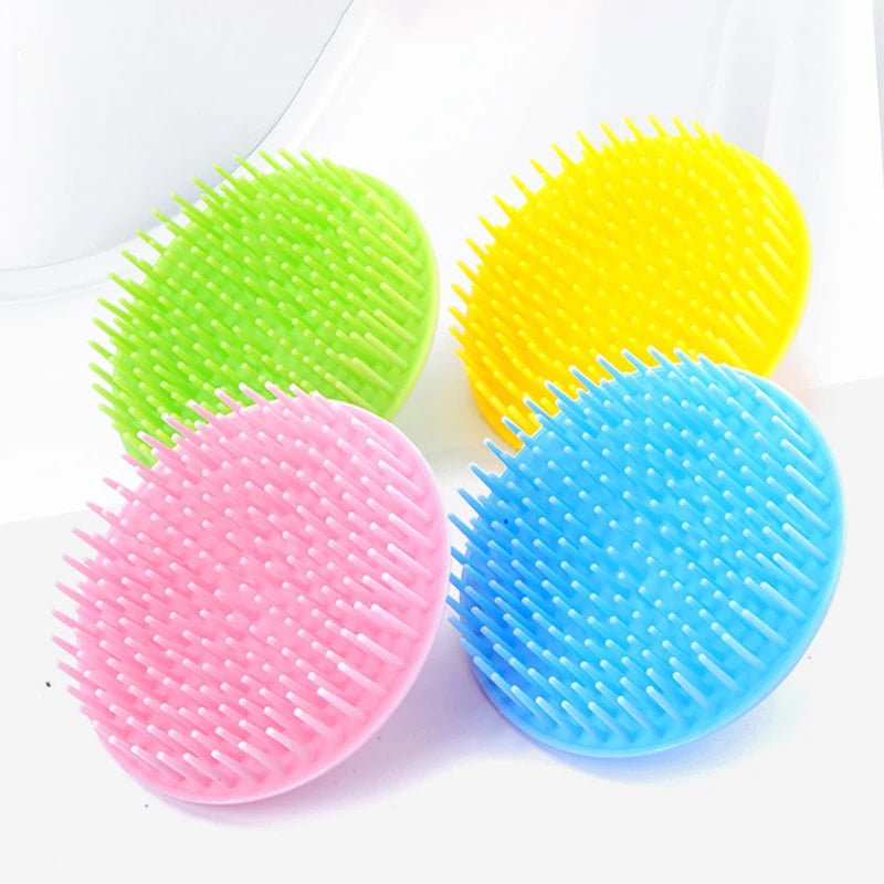 Three silicone hair and scalp massage brushes in green, yellow, and blue are displayed on a white background.