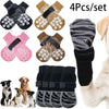 Set of four anti-slip dog socks with traction straps in black, pink, and brown colors.
