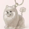 Figurine en résine blanche brillante d'un chien moelleux assis, attachée à une clé USB argentée.