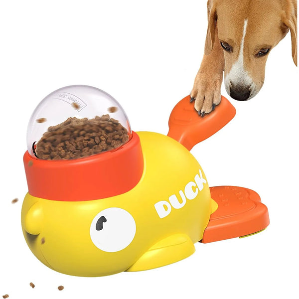 A yellow interactive treat dispenser for dogs with an orange lid and a dog's paw reaching into the food bowl.