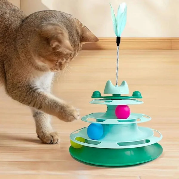 A cat is interacting with a multi-tiered, colorful interactive toy tower featuring a turntable and feather balls.