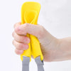 A hand is holding a yellow quack-free training muzzle for small dogs.