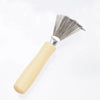 A natural wooden hairbrush cleaner with a light wood handle and metal bristles.