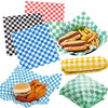 A collection of colorful checkerboard oil-proof sandwich wrapping paper sheets and prepared food items like sausages and fren