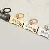 A set of custom engraved bone-shaped stainless steel dog ID tags in various colors and finishes.