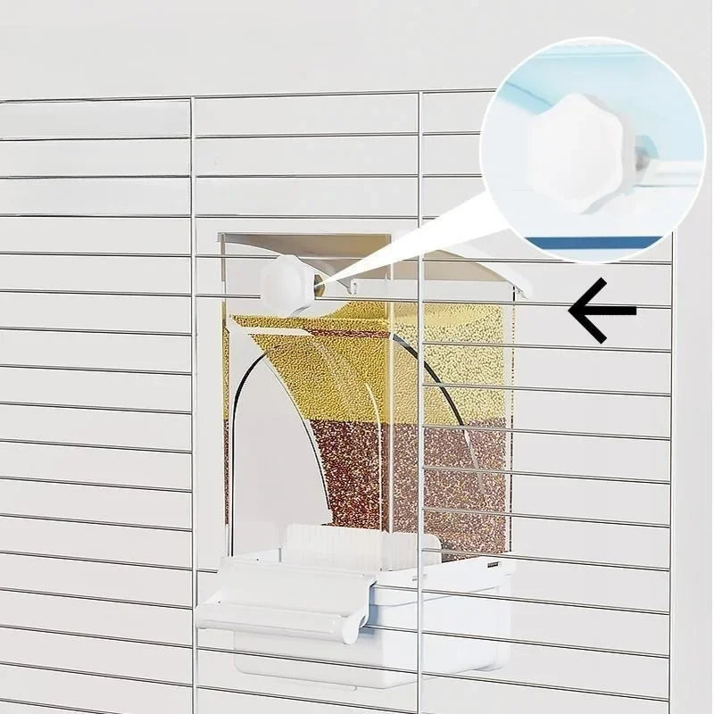 Close-up view of an automatic parrot feeder with husk separation mechanism inside a white grid frame.