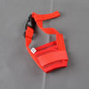 An orange breathable dog muzzle with black strap and soft padding shown against a gray background.