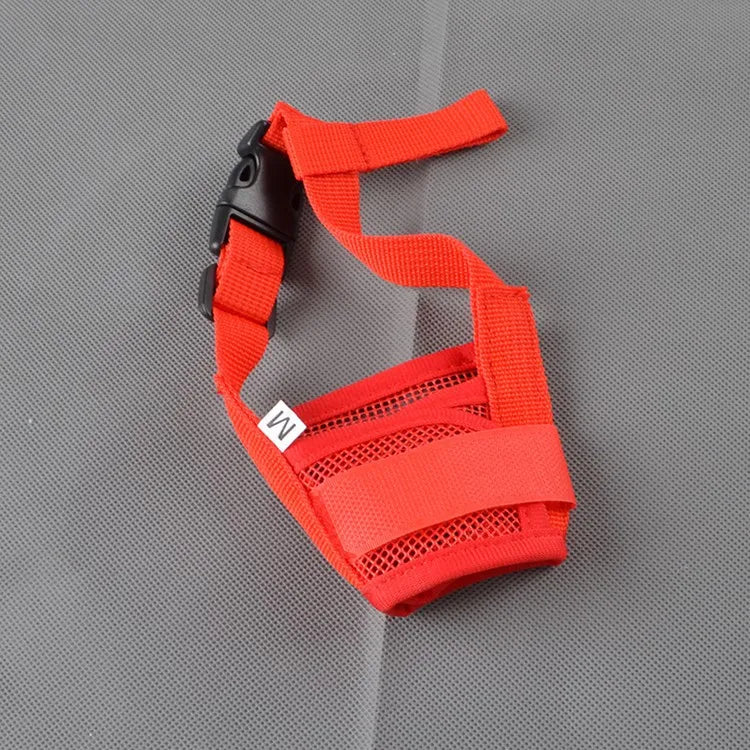 An orange breathable dog muzzle with black strap and soft padding shown against a gray background.