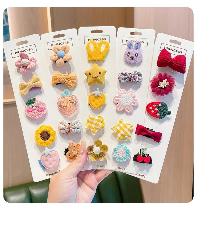 A display of five adorable flower-shaped baby hair clips in various colors and textures.