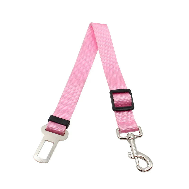 Pink retractable dog car seatbelt tether with a buckle for headrest restraint.