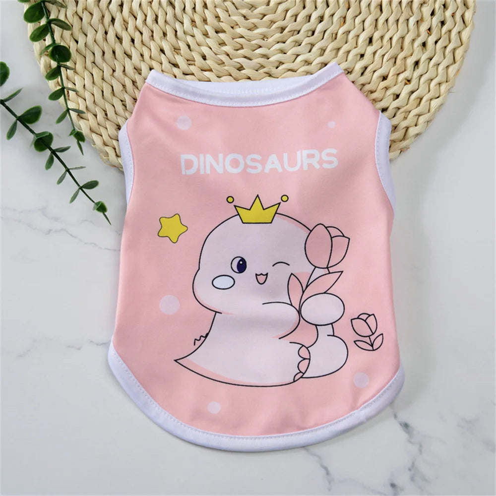 A pink dinosaur-themed vest shirt for a small dog is displayed on a white marble surface.