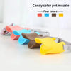 A collection of candy colored silicone dog muzzles in red, blue, brown, and yellow displayed on a white surface.
