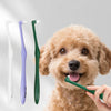 A golden retriever puppy is being groomed with a green soft bristle pet toothbrush.
