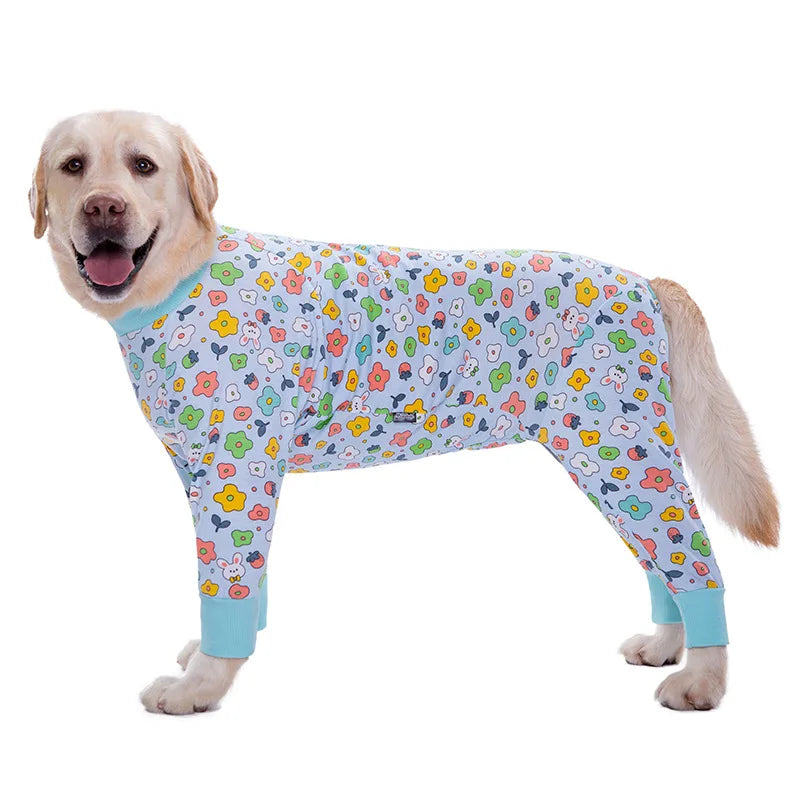 A golden retriever wearing a colorful cartoon animal print jumpsuit.