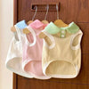 Three pastel knitted dog shirts with lapel collars hanging on a wooden rack