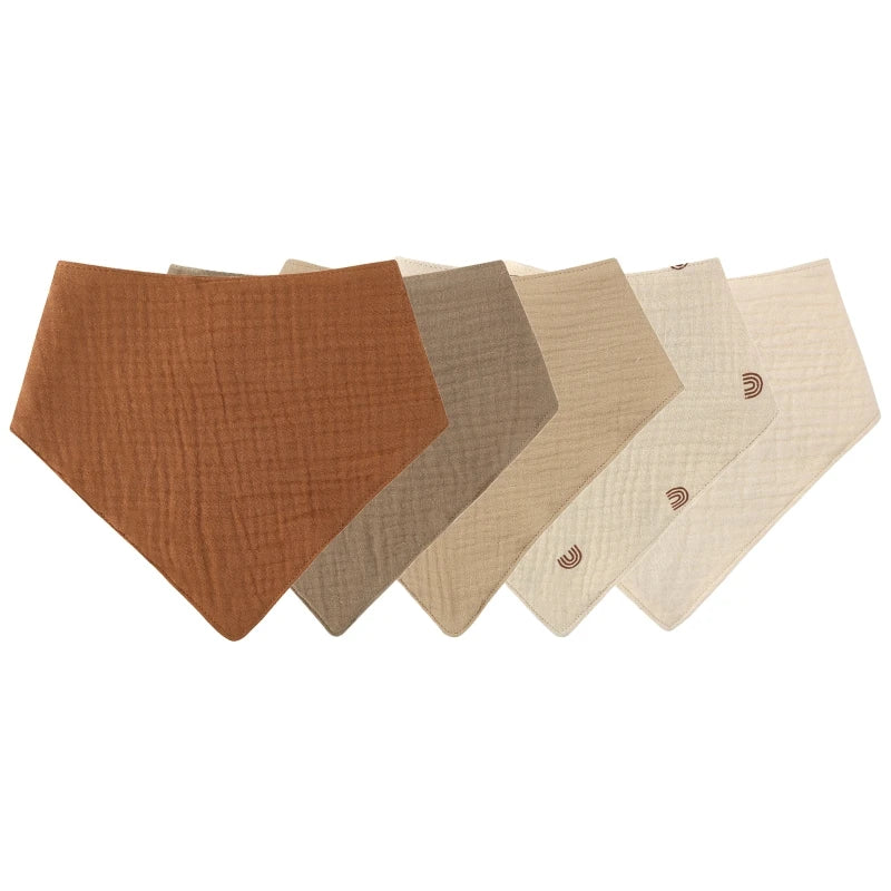 A row of five soft cotton baby bibs in varying shades of brown and beige.