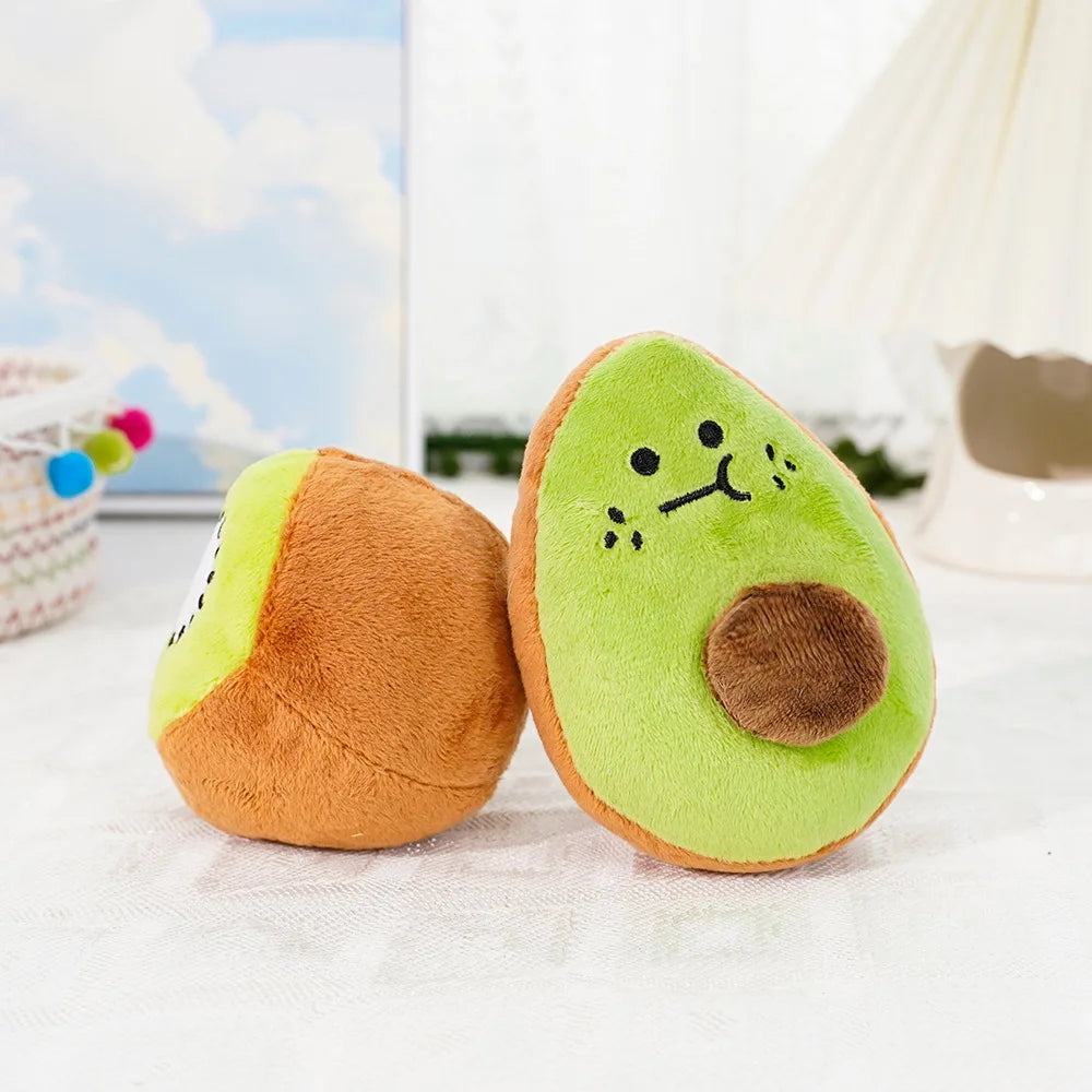 A plush toy shaped like an avocado with a kiwi slice detail, sitting on a white surface.