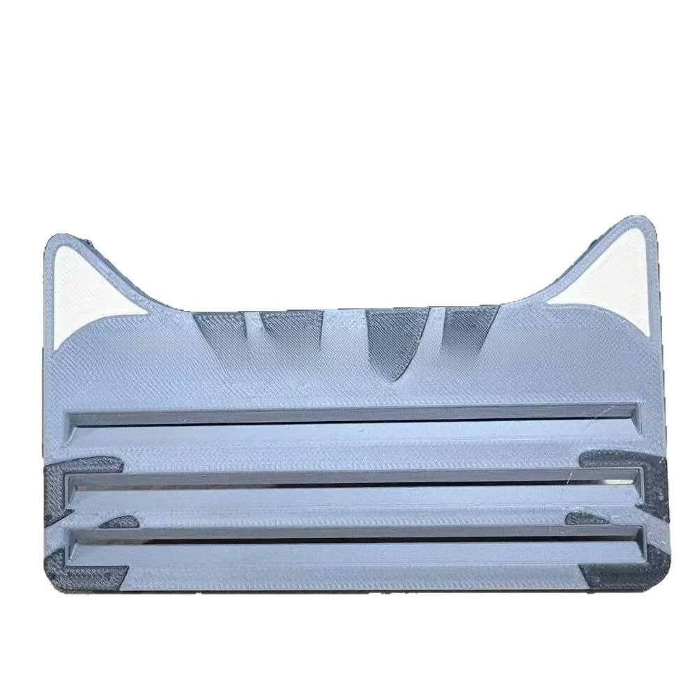 A reusable cat food pouch scraper made of gray silicone with multiple blades for opening pouches.