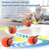 An orange electric cat ball toy is shown rolling across a floor, demonstrating an unpredictable movement path.