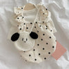 A white summer dot pet dress for a small dog with ruffled trim and a large embroidered face detail.