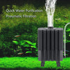 A black pneumatic filtration device for quick water purification, shown outdoors with lush green foliage.