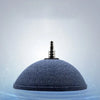 A dark blue, dome-shaped aquarium air stone disc floating in clear water.