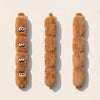 Three fluffy brown dog chew toys shaped like dogs with numbers on them displayed against a light background.