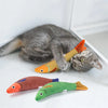 A gray cat is lying next to an orange and yellow fish plush toy for cats.
