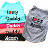 A stack of light blue and gray shirts featuring text like I love my Daddy, Mommy, and Daddy, Mommy.