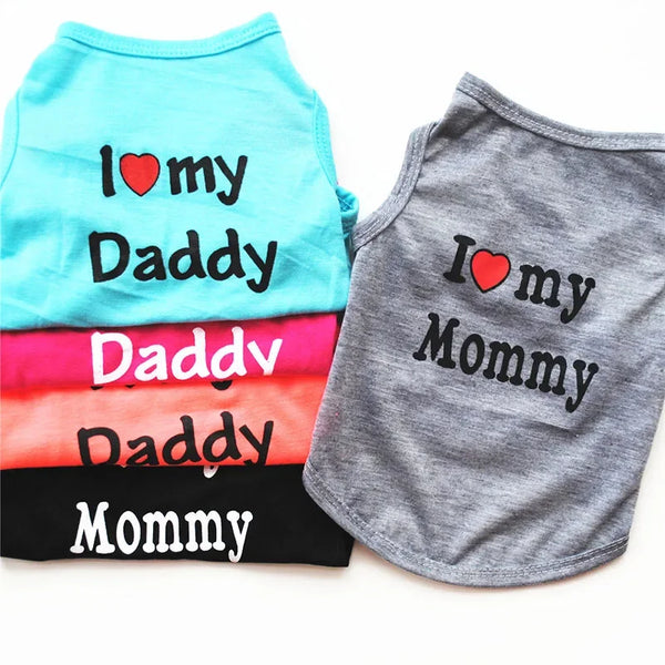 A stack of light blue and gray shirts featuring text like I love my Daddy, Mommy, and Daddy, Mommy.